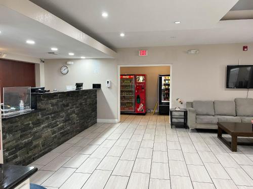 a lobby with a waiting room with couches and a tv at Studio 6 Suites North Richland Hills TX in North Richland Hills