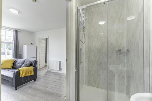 szklany prysznic w salonie z kanapą w obiekcie Comfy Stay 1 Bedroom Apartment w mieście Rugby
