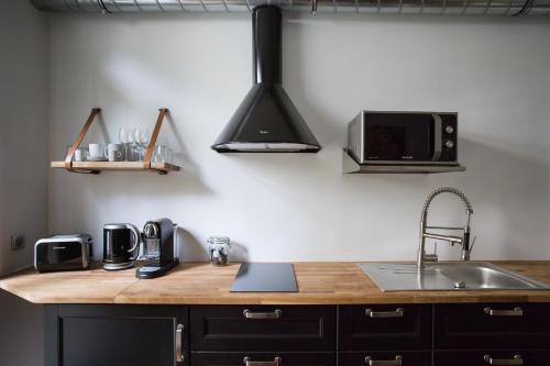 un comptoir de cuisine avec un évier et un micro-ondes dans l'établissement Duplex cinéma face au Parc des Expositions, à Paris