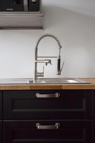 un comptoir de cuisine avec un évier et un micro-ondes dans l'établissement Duplex cinéma face au Parc des Expositions, à Paris