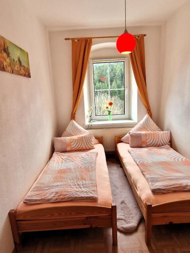 two beds in a room with a window at Ferienwohnungen "Am Schlössel" in Kurort Oberwiesenthal