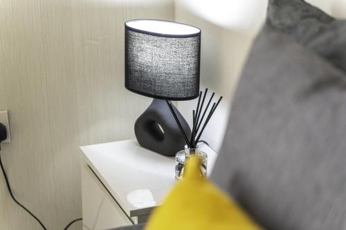 a lamp sitting on a table next to a bed at Comfy Stay 1 Bedroom Apartment in Rugby
