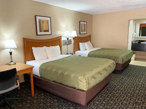 a hotel room with two beds and a desk at Studio 6 Suites North Richland Hills TX in North Richland Hills