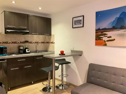 a kitchen with a counter and a table and chairs at Encantocandelaria in Bogotá