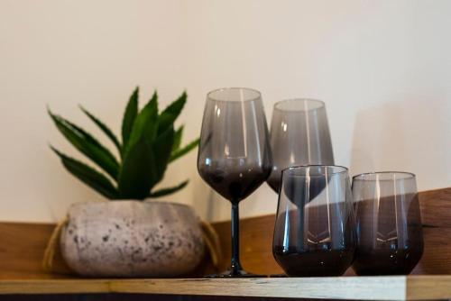drie wijnglazen en een potplant op een tafel bij Wanderer, Nilie Hospitality MGMT in Thessaloniki