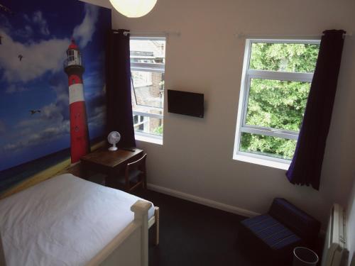 a bedroom with a bed and a mural of a lighthouse at Igloo Hybrid in Nottingham