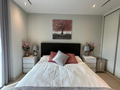 a bedroom with a large bed with two night stands at Marina Club - Luxury Apartment in Ocean Village with Parking in Gibraltar