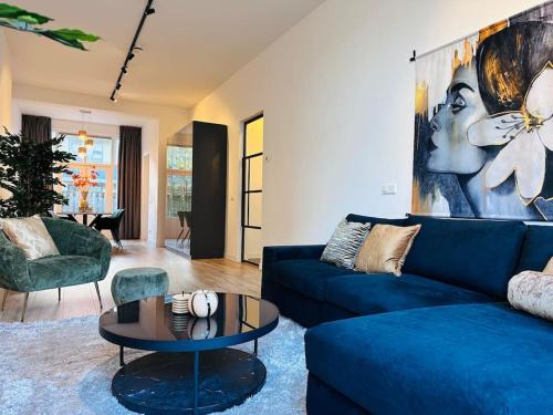 a living room with a blue couch and a table at Sofia's Mansion in Breda