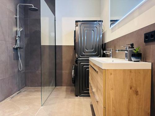 uma casa de banho com um chuveiro, um lavatório e um frigorífico em Sofia's Mansion em Breda