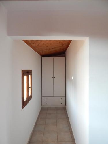 a room with a hallway with white walls and a window at Kaina Villa in Vamos