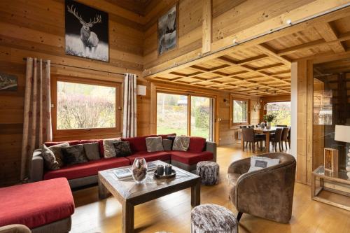 ein Wohnzimmer mit einem roten Sofa und einem Tisch in der Unterkunft Chalet with 5 beds 4 bath Hot Tub & Sauna - At Pangea in Les Houches