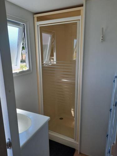 une salle de bain avec douche et lavabo dans l'établissement LE RHUYS, mobil home cosy proche des plages, à Sarzeau