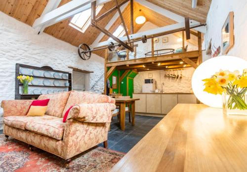 a living room with a couch and a table at Ysgubor - Tranquil space for two in Saint Dogmaels