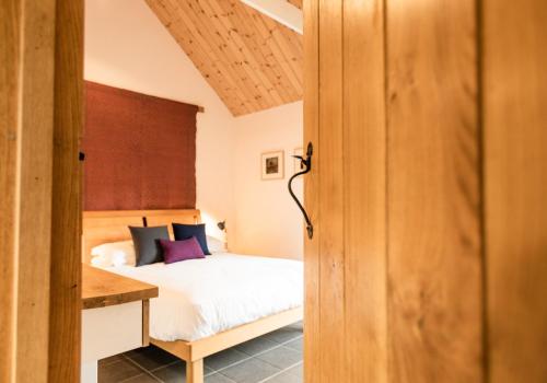 una camera da letto con un letto e una scrivania di Ysgubor - Tranquil space for two a Saint Dogmaels
