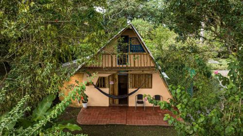 a house is seen through a tree frame at Finca Ecológica El Maco in San Agustín