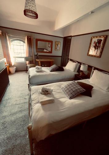 a hotel room with two beds with towels on them at THE ITALIAN GREYHOUND in Great Glen