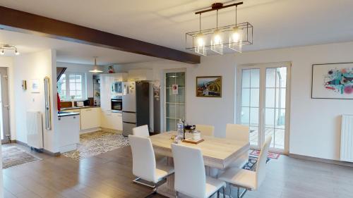 une cuisine et une salle à manger avec une table et des chaises dans l'établissement Ô calme Maison familiale - Wickerschwihr, à Wickerschwihr