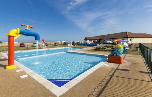 a pool with a water slide and a water park at Coastguard 45 in Whitstable