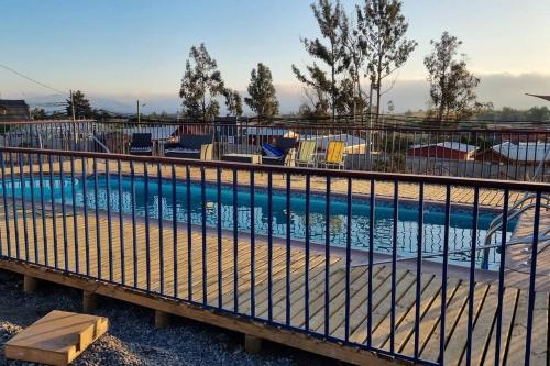 uma piscina com uma cerca à volta em Cabaña familiar con piscina a pasos de San Antonio, en Quillaycillo em El Tabo