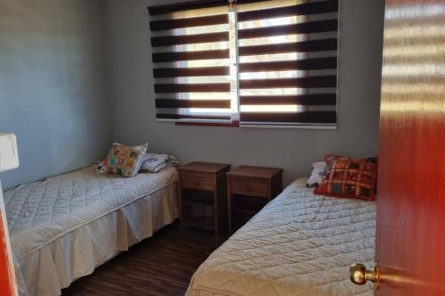 1 dormitorio con 2 camas y ventana en Cabaña familiar con piscina a pasos de San Antonio, en Quillaycillo, en El Tabo