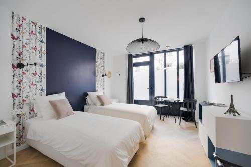 a hotel room with two beds and a table at Studio "Café Papillon"-Paris 15 in Paris