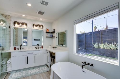 uma casa de banho com uma banheira, um lavatório e uma janela em Modern Palm Springs Home with Pool and Gas Fire Pit! em Palm Springs