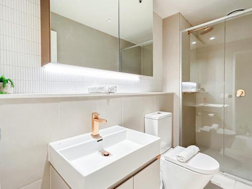 uma casa de banho branca com um lavatório e um WC em Beautiful City View 2br1ba In Melbourne Cbdwifi em Melbourne