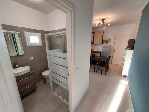 uma casa de banho com um lavatório, um WC e uma mesa em ApartmentsGarda - Velia 23 em Lazise