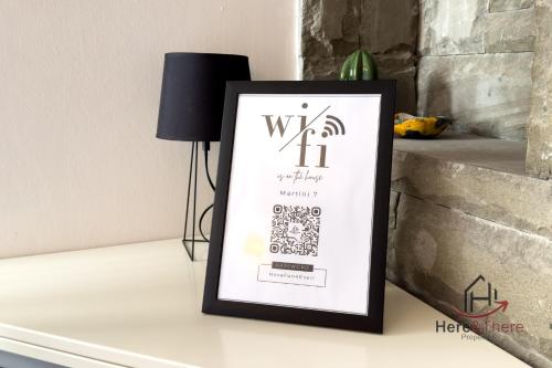 a framed picture on a table next to a lamp at Beaches 1 min away - Free WiFi - Smart TV - AC in Albisola Superiore