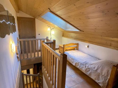 Villard-sur-DoronにあるAppartement Villard-sur-Doron, 4 pièces, 9 personnes - FR-1-293-89の木製の天井の客室で、ベッドルーム1室(ベッド1台付)