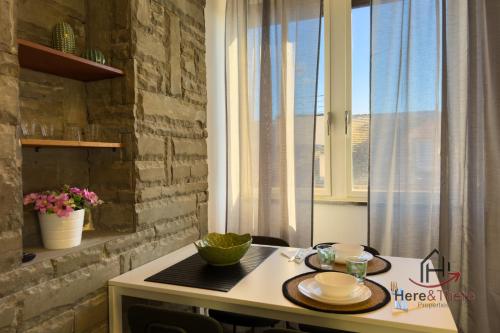 a kitchen with a table with two plates on it at Beaches 1 min away - Free WiFi - Smart TV - AC in Albisola Superiore