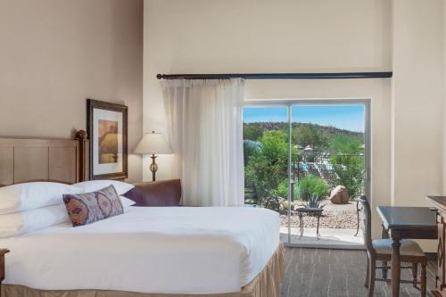 a hotel room with a bed and a large window at JW Marriott Tucson Starr Pass Resort in Tucson