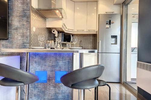 uma cozinha com 2 bancos e um frigorífico em HENRI CAMILLE REAL ESTATE -LOUIS - Studio premium city center em Cannes