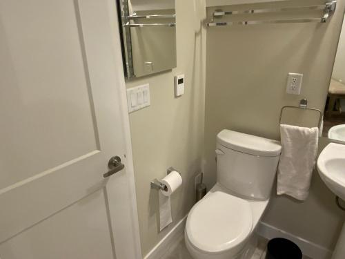 a white bathroom with a toilet and a sink at Cozy Living in Surrey