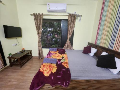 a bedroom with a bed with a blanket on it at Bhumi Holiday Home in Alibaug