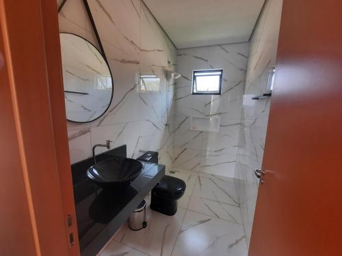 ein Badezimmer mit einem Waschbecken und einer Marmorwand in der Unterkunft Rancho Teixeira in Alexânia