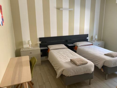 um pequeno quarto com duas camas e uma mesa em Lisonino House em SantʼAngelo Lodigiano