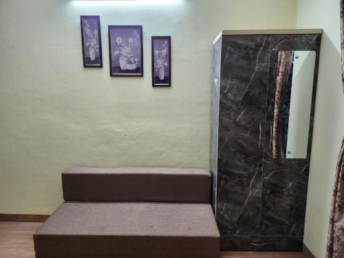 a room with a bench and pictures on the wall at Bhumi Holiday Home in Alibaug