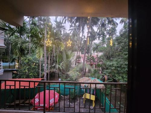 a balcony with a view of a pool and trees at Bhumi Holiday Home in Alibaug