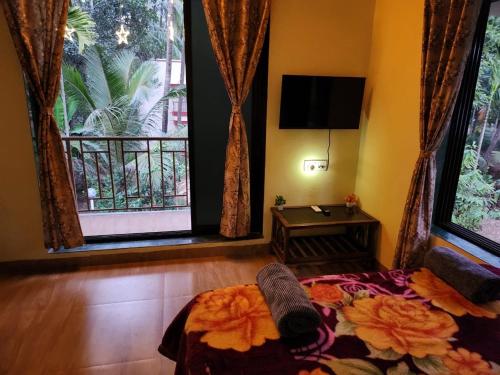 a room with a bed and a large window at Bhumi Holiday Home in Alibaug