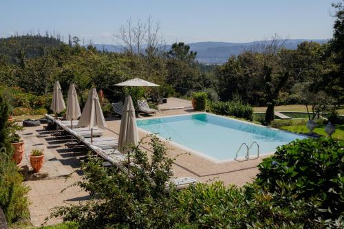 サン・ペードロ・ド・スーにあるThe Fox House - Private Villa & Natureのパラソルと椅子付きのスイミングプール、プールを提供しています。