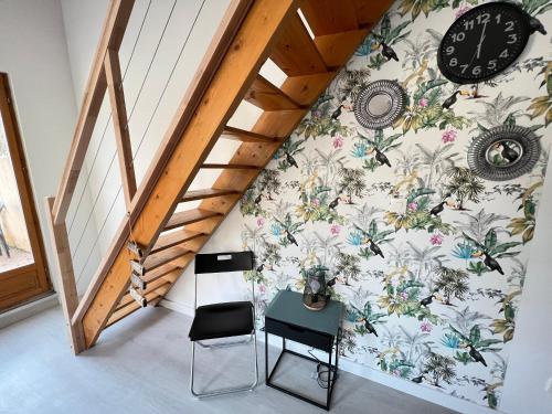 Cette chambre comprend un bureau et une horloge murale. dans l'établissement La Maisonnette Un Séjour à Part, à Longeville-lès-Metz