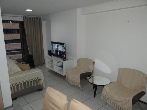 a living room with a couch and chairs and a tv at Ocean Atlantic Praia de Iracema in Fortaleza