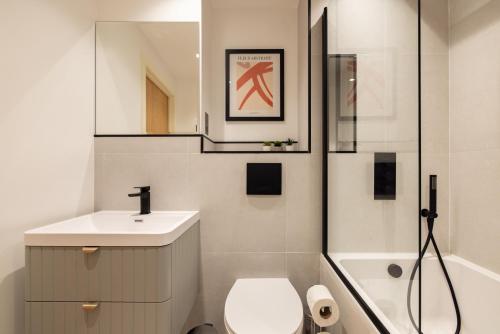 a bathroom with a sink and a toilet and a mirror at The Wembley Place - Stunning 1BDR Flat in London