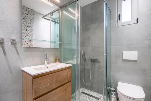 a bathroom with a sink and a glass shower at Athena's South Apartment in Athens