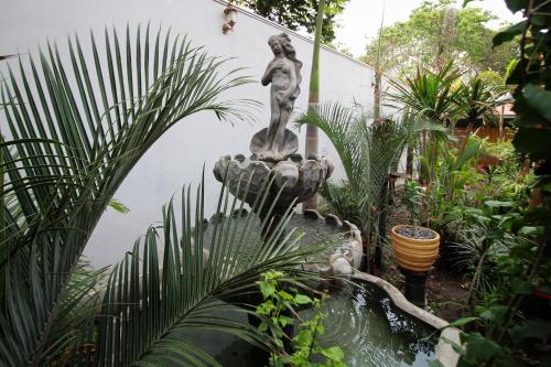 a fountain in the middle of a garden at Villa Éden in Alter do Chao