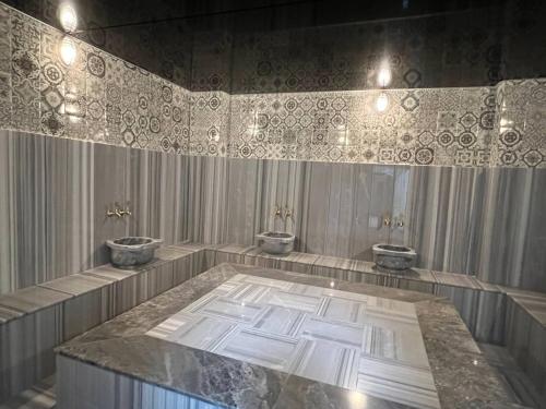 un baño con tres lavabos y dos inodoros en Art Life apartments (Sunset), en Alanya