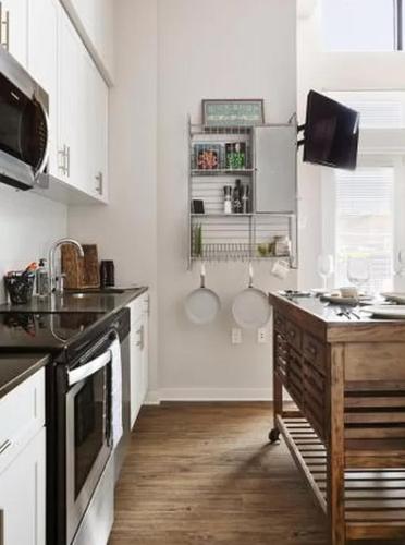a kitchen with white cabinets and a wooden counter top at Restful Studio Apartment in NYC! in New York