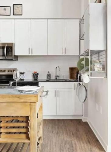 a kitchen with white cabinets and a sink at Restful Studio Apartment in NYC! in New York