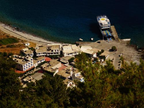 a large cruise ship is docked at a beach at Paralia guest house in Agia Roumeli